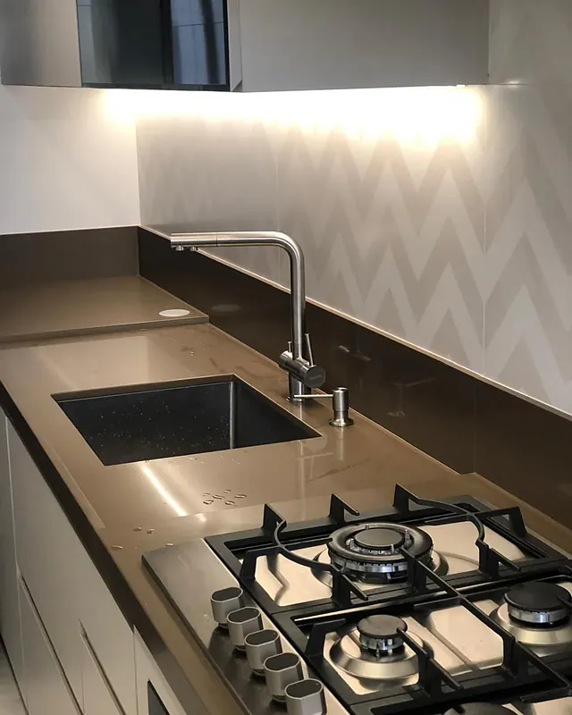 Bancada escura com cuba de embutir, torneira gourmet e cooktop