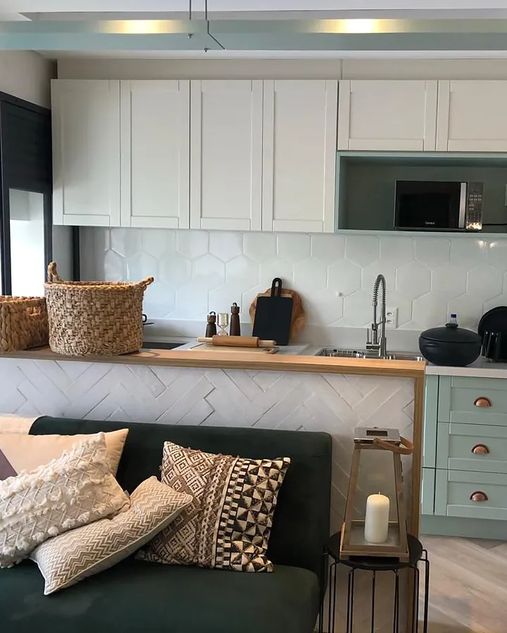 Sala ampla integrada à cozinha planejada com armários claros
